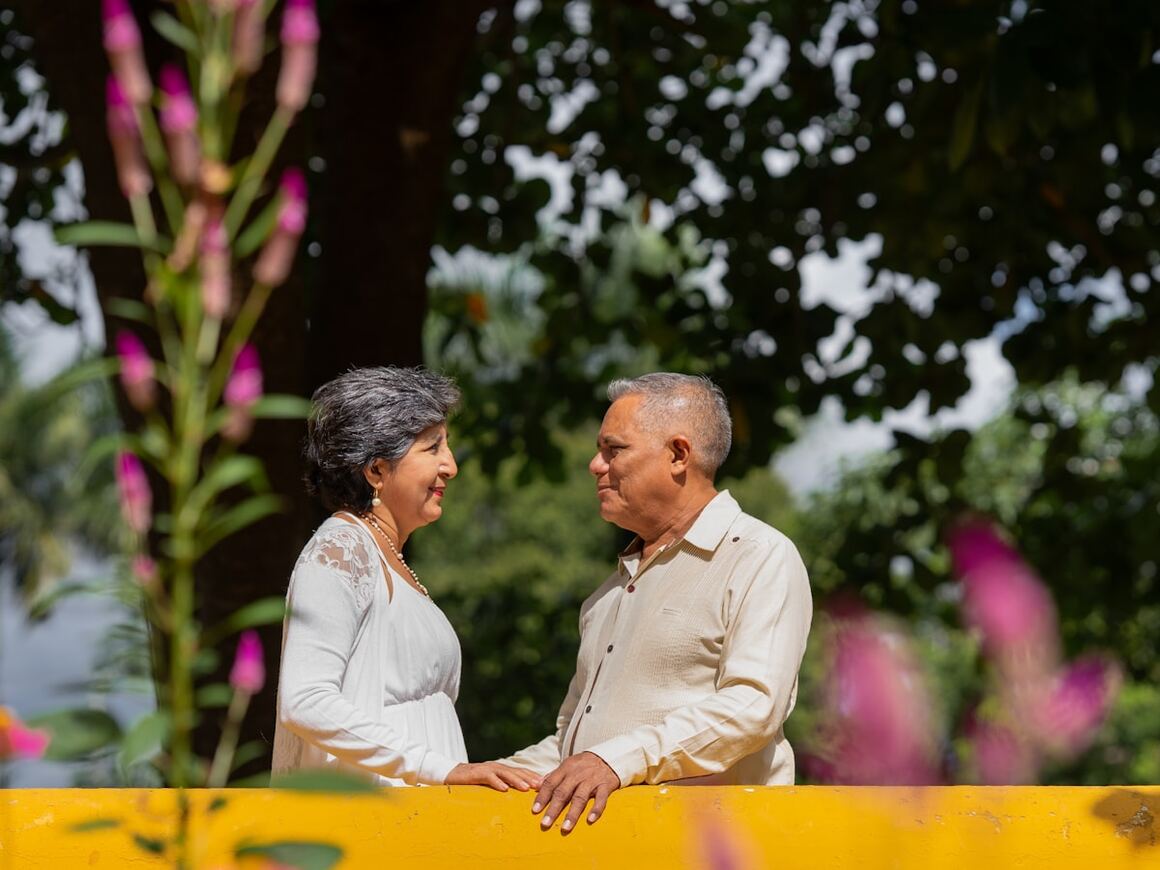An older couple smiling together outdoors.